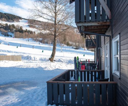 a porch of a house with skis in the snow at Koselig leilighet med Ski Bike in and out Nr 34 in Hafjell