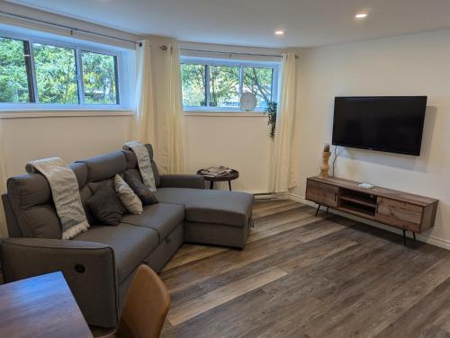 a living room with a couch and a flat screen tv at Lac et Montagne Eastman in Eastman