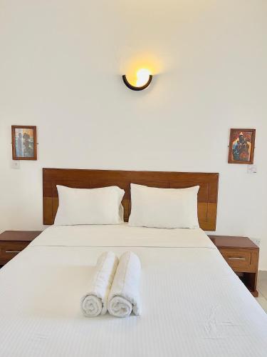 a bedroom with a white bed with towels on it at Nyali Exquisite 2 bedroom behind City Mall-Swanky in Mombasa