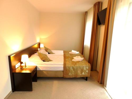 Un pat sau paturi într-o cameră la Hotel Świętoborzec