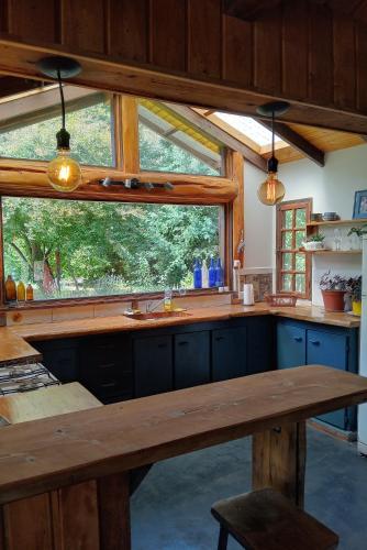 a kitchen with a large window and a wooden table at Quinta Armonía Cabaña in Lago Puelo