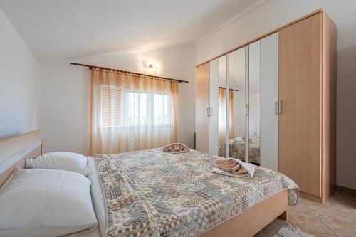 a bedroom with a large bed and a mirror at Vladivostok Apartments in Tivat