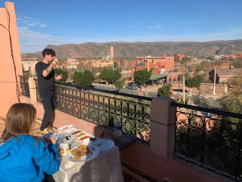 a man standing on a balcony with a woman eating food at riad lala fatima in Ouzoud