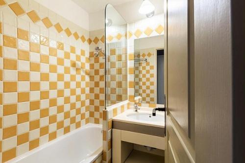 une salle de bain avec une baignoire et un lavabo et une baignoire dans l'établissement Résidence Cannes Villa Francia - maeva Home - Appartement 2 pièces 4 personnes - Sélection MAE-5131, à Cannes