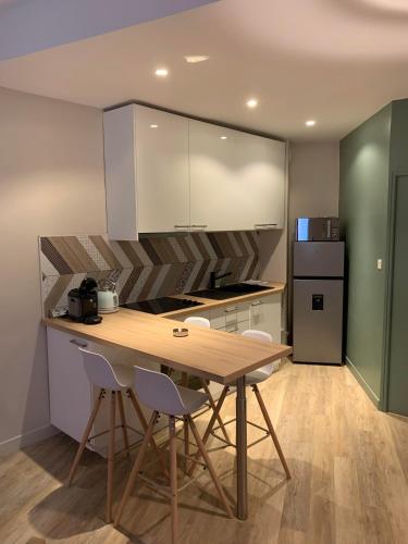 une cuisine avec une table et des chaises en bois dans l'établissement Appartement hyper centre Rennes, à Rennes