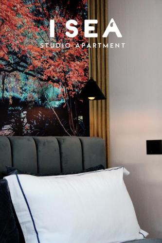 a bed in a hotel room with a painting on the wall at Isea Studio Apartment in Korçë