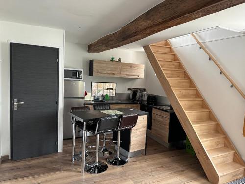 - une cuisine avec une table et un escalier dans une chambre dans l'établissement cottage Philippe et Valérie, à Silli-en-Gouffern