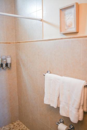 a bathroom with a shower with white towels at Island Charm Culebra - Studios & Suites - Amazing Water views in Culebra Puerto Rico! in Culebra
