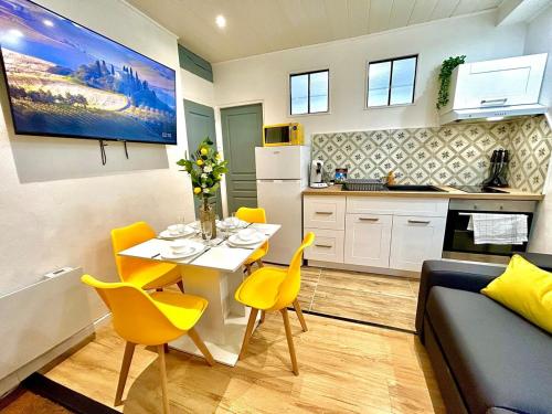 Il dispose d'une cuisine et d'un salon avec une table et des chaises jaunes. dans l'établissement Le Zeste, centre parking gratuit, à Villeneuve-sur-Yonne