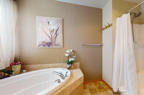 a bathroom with a white tub and a shower at East Wenatchee Serenity Hills in East Wenatchee Bench