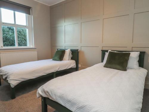 a bedroom with two beds and a window at Homewood in Preston