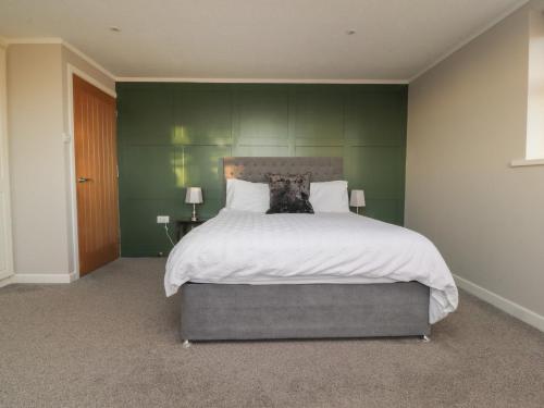 a bedroom with a large bed with a dog on it at Homewood in Preston