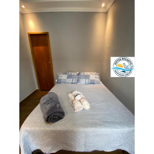 a bedroom with a bed with towels on it at Pousada Recanto Beach House-CaboFrio-Unamar-condominio Florestinha in Cabo Frio