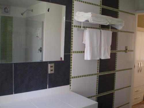 a bathroom with a sink and a shower with towels at Bolivian Rooms & Suites (Zona Sur) in La Paz