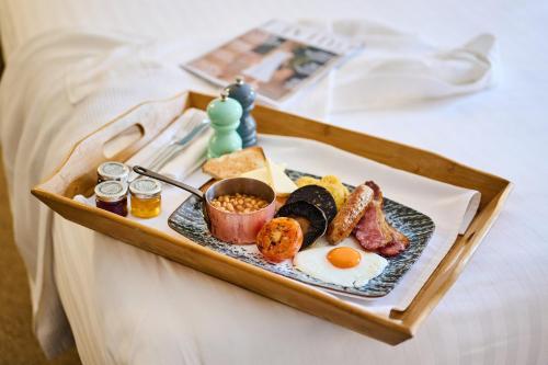 a tray of breakfast food on a bed at Milford Hall Salisbury in Salisbury