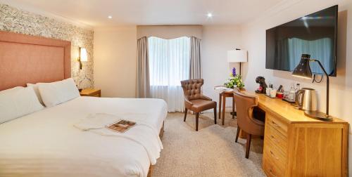 a hotel room with a bed and a desk at Milford Hall Salisbury in Salisbury