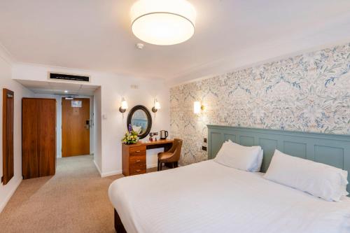 a bedroom with a bed and a desk with a mirror at Milford Hall Salisbury in Salisbury