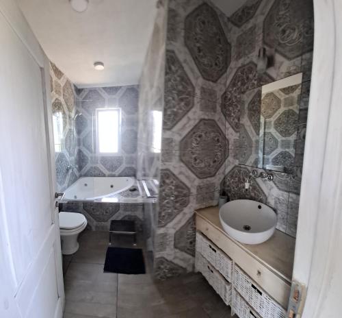 a bathroom with a sink and a tub and a toilet at Sagastume in Las Toninas