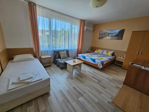 a hotel room with a bed and a couch at Къща за гости Ани in Chernomorets