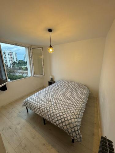 une chambre avec un lit dans une pièce avec une fenêtre dans l'établissement Appartement 3 chambres lumineux, à Perpignan