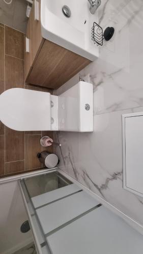 La salle de bains est pourvue d'un lavabo et d'un comptoir en verre. dans l'établissement Petit nid douillet à 25 min de Paris tout confort, à Bouffémont