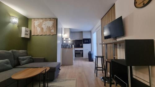 un salon avec un canapé et une table et une cuisine dans l'établissement Petit nid douillet à 25 min de Paris tout confort, à Bouffémont