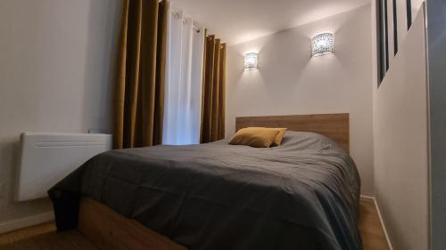 Ce lit se trouve dans un dortoir doté de 2 lumières sur le mur. dans l'établissement Petit nid douillet à 25 min de Paris tout confort, à Bouffémont