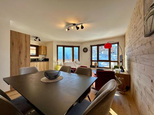 une salle à manger avec une table et des chaises dans l'établissement Homency - Résidence L'Expression B11, à L'Alpe-d'Huez