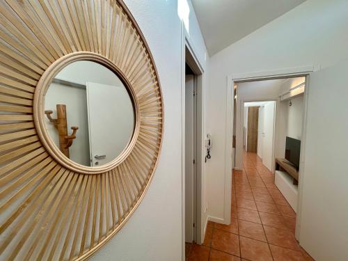 a round mirror on a wall in a hallway at Stefano's cozy Apartment in Erba