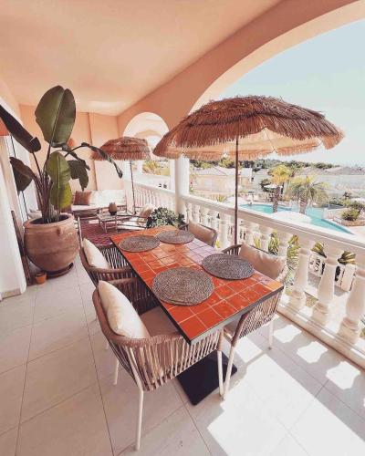 - une salle à manger avec une table, des chaises et des parasols dans l'établissement Boho chic Ibiza vibe appartment 4p, à Benissa