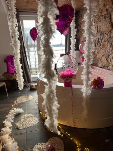 a room with a tub with pink and white decorations at EGZOTYCZNO - ROMANTYCZNE miejsce dla DWOJGA in Ełk