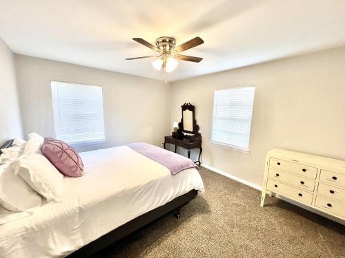 a bedroom with a bed and a ceiling fan at The Purple House - Cozy Near TSU in Stephenville