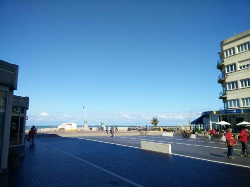 people walking on a street near the beach at Rewindhotel in Oostduinkerke