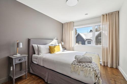 a bedroom with a large bed and a window at Condos Kamik Tremblant by Manitonga in Mont-Tremblant