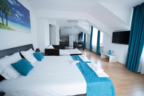 a bedroom with a large white bed with blue pillows at Guest house Traikovi in Petrich