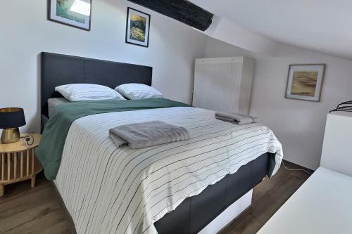 - une chambre dotée d'un grand lit avec des draps blancs et verts dans l'établissement Charmant duplex Béziers centre, à Béziers