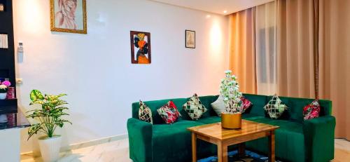 a living room with a green couch and a table at Dar Noureddine in Lalla Takerkoust