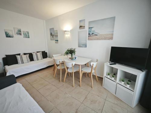 ein Wohnzimmer mit Tisch und ein Schlafzimmer in der Unterkunft EL ESTUDIO DE LA PLAYA BENALBEACH Vistas al Mar in Benalmádena