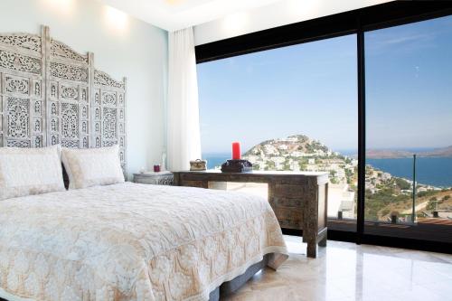 a bedroom with a bed and a view of the ocean at Villa Calista by Important Group Travel in Yalıkavak