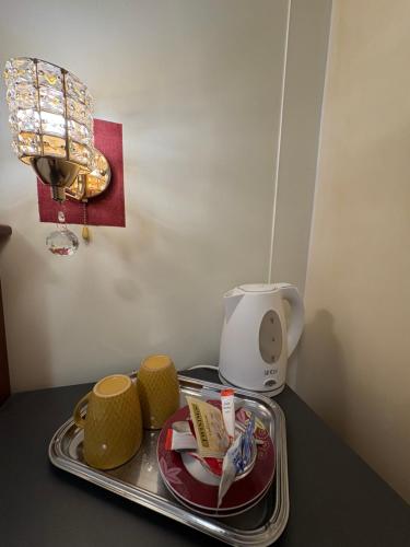 a tray with plates and cups on a table at Esos Hotel Quelle in Bad Ragaz
