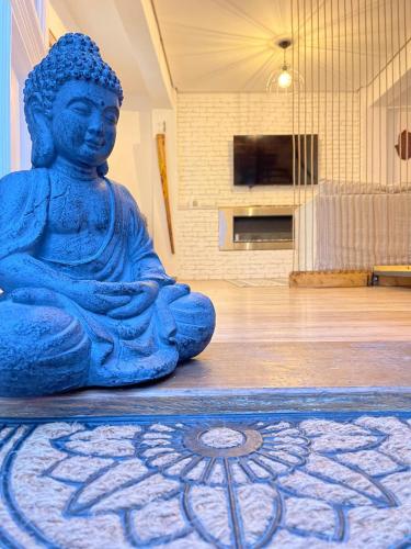 a statue of a buddha sitting on the floor at Saints & Sinners Romantic Jacuzzi in Bucharest