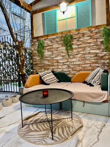 a patio with a couch and a table at Saints & Sinners Romantic Jacuzzi in Bucharest
