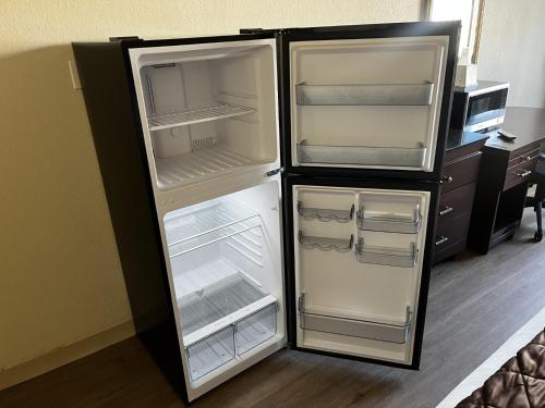 an empty refrigerator with its doors open in a room at Budget Inn Laramie in Laramie