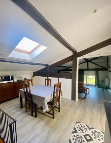 d'une salle à manger avec une table, des chaises et une lucarne. dans l'établissement Charmante dépendance, à Izon
