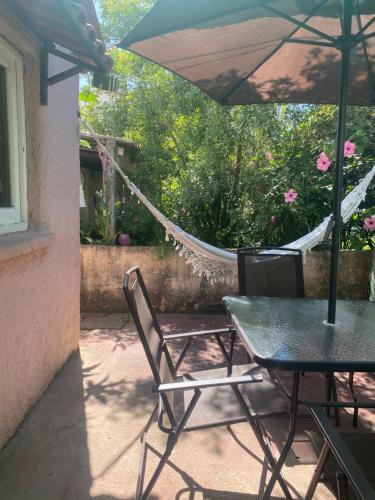 a patio with a table and chairs and a hammock at Casa rosa - se reserva con seña in Barra del Chuy
