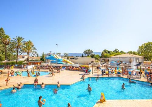 un groupe de personnes dans une piscine d'un complexe hôtelier dans l'établissement Mobile home sirène luxe Camping le Bosc 4 étoiles 3 chambres, à Saint-Cyprien