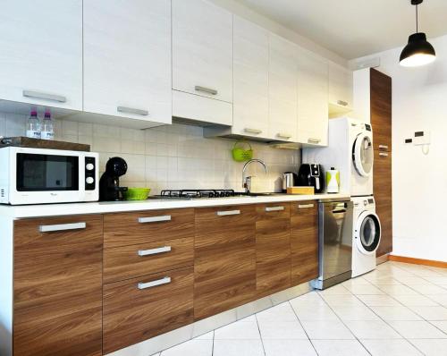 a kitchen with white cabinets and a microwave and a stove at Jeemma in Galliera Veneta