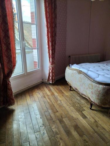 - une chambre avec un lit installé à côté d'une fenêtre dans l'établissement Au coeur d'un village creusois, à Néoux