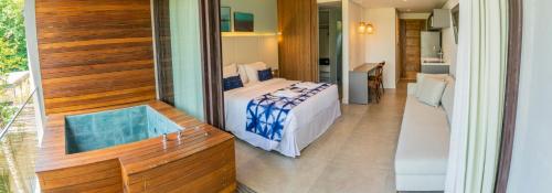a room with a bed and a bath tub at Wyndham Ilhabela Casa Di Sirena in Ilhabela