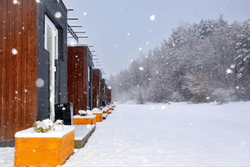 a snow covered street with a row of buildings at Sherwood Lake Hotel in Berezovka